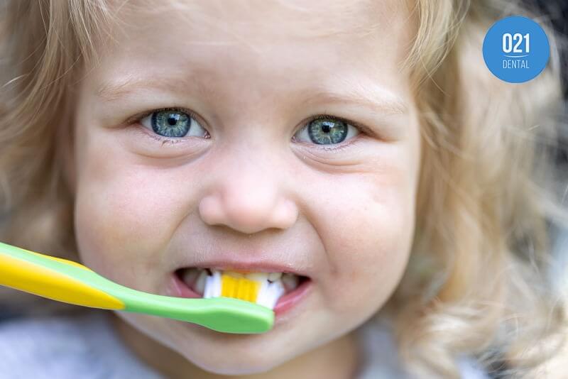 criança escovando seus dentes de leite