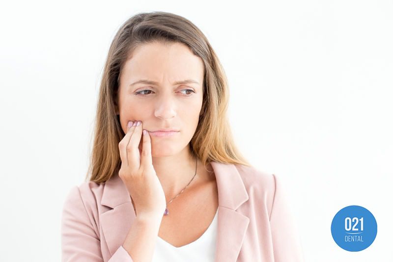 Mulher sentindo dor de dente causada por infiltração
