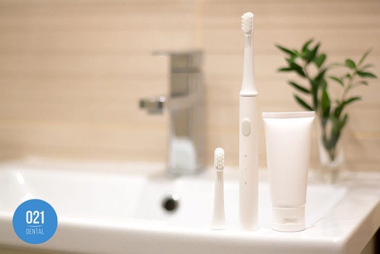 escova de dentes elétrica posicionada na pia do banheiro