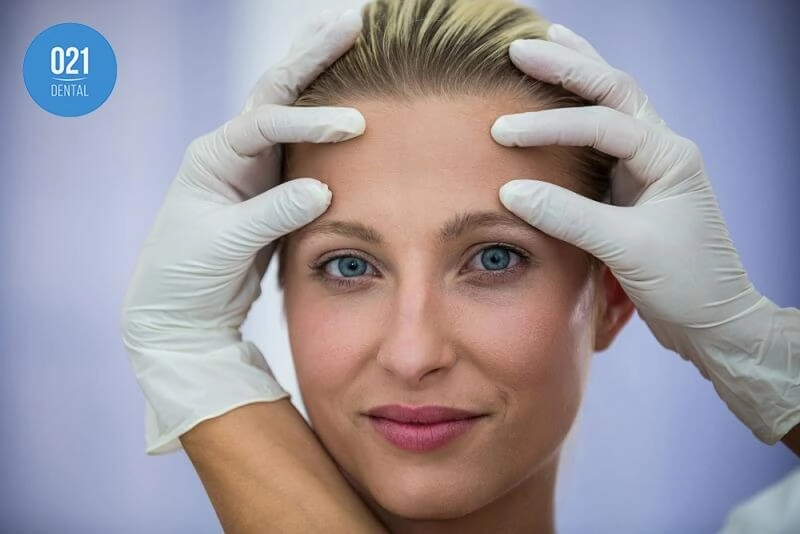 Imagem de uma mulher em avaliação para procedimentos faciais
