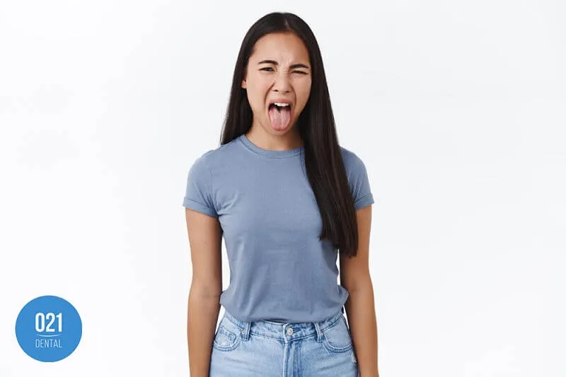 Imagem com fundo branco de uma mulher mostrando a língua 