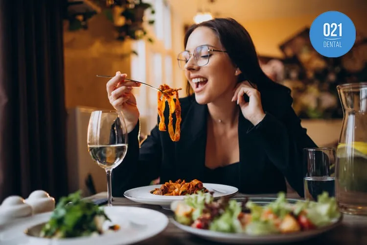 Imagem de uma pessoa comendo macarrão em um restaurante chic